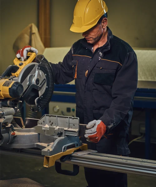carpenter-male-dressed-safety-yellow-cap-works-with-chain-saw-garage (1)